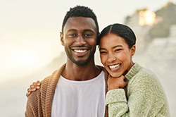 Male student sitting at desk reads braille to his teacher